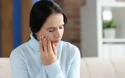 Woman suffering from Jaw Pain